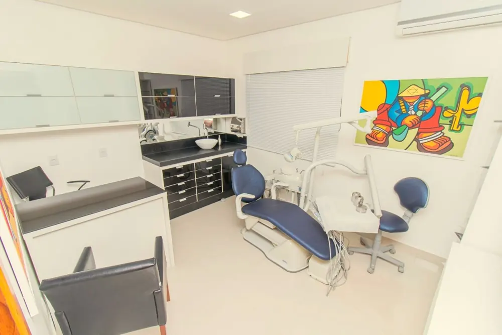 Consultório com cadeira odontológica e quadro colorido