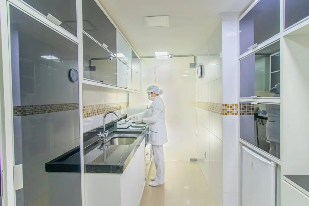 Profissional com equipamento de proteção preparando materiais na sala de esterilização